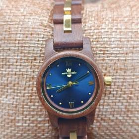 montre en bois pour femme couleur bleue posée sur un coussin