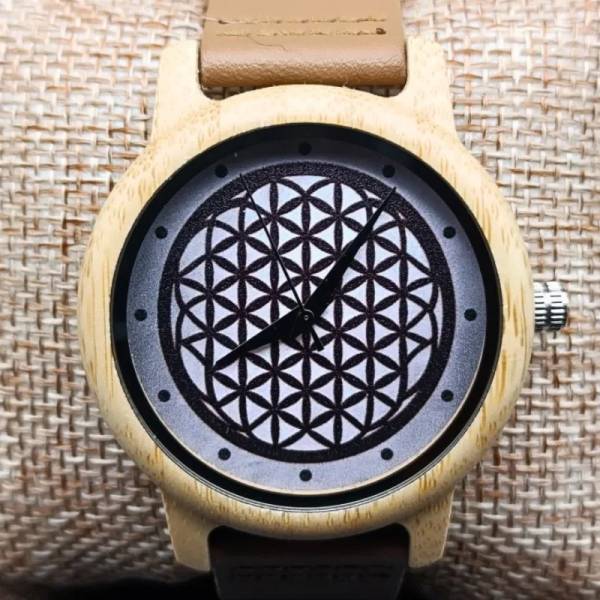 Montre en bois spirituelle fleur de vie posée sur un coussin